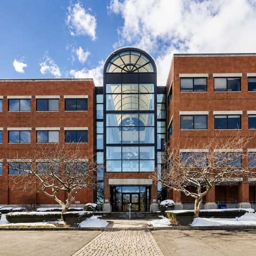 Existing brick and glass atrium entrance facade with arched skylight